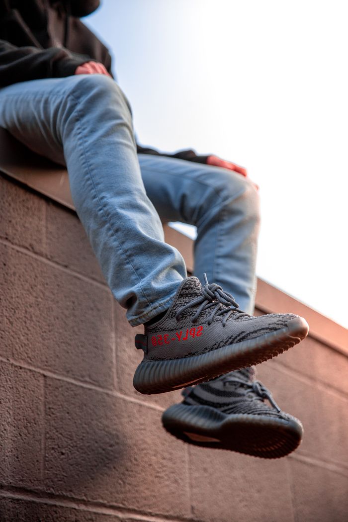 Services Stylish sneakers worn by a person sitting on a wall, showcasing timeless fashion.