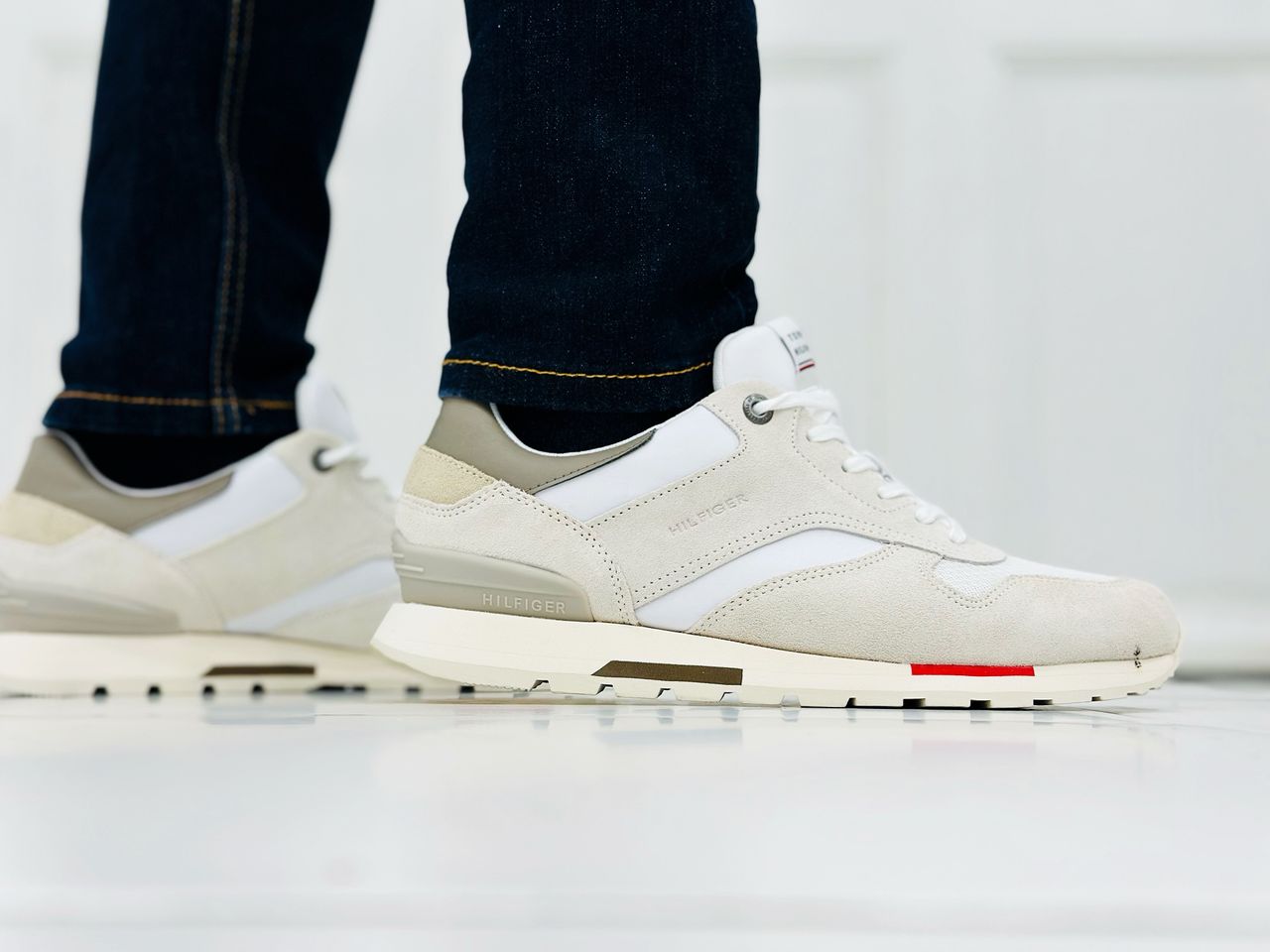 Services Fashionable close-up of white casual sneakers and jeans indoors.